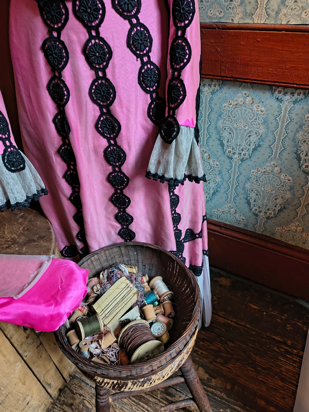 Photo of a pink dress and a basket full of thread