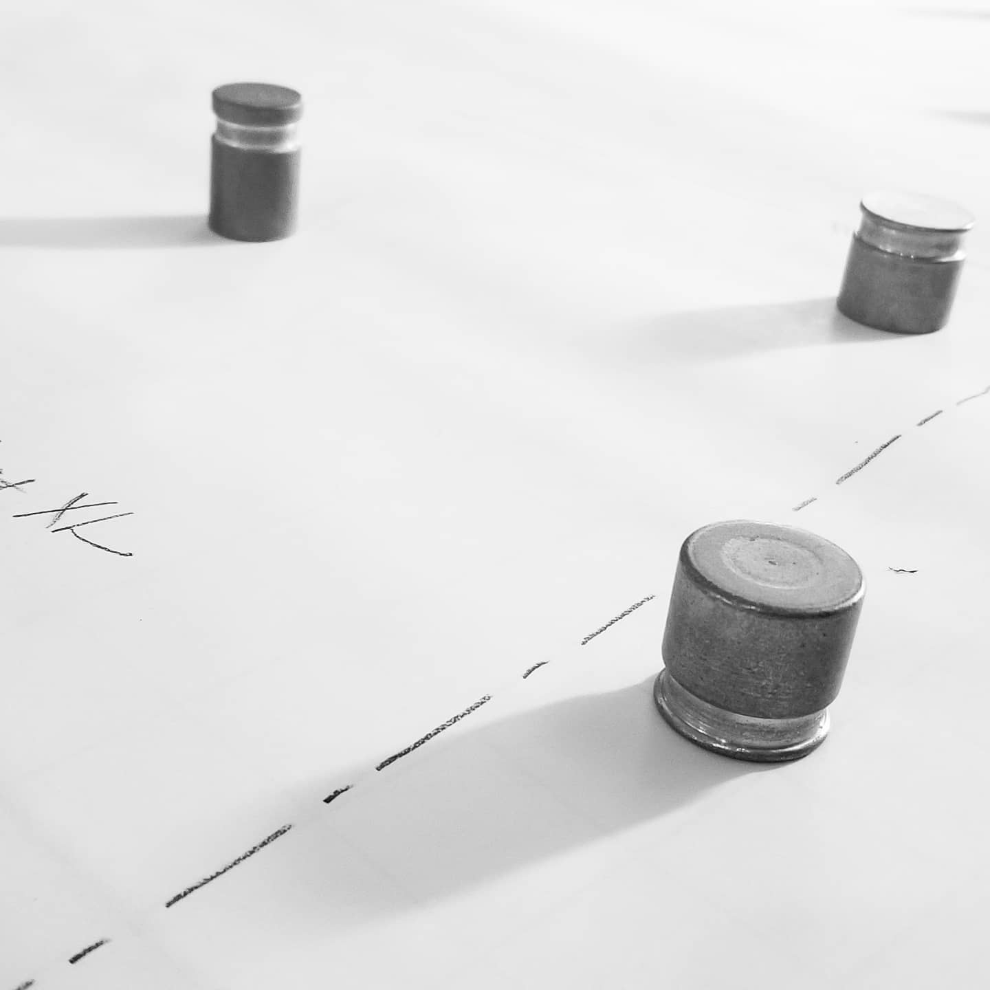 Black and white photo of pattern weights on a paper pattern